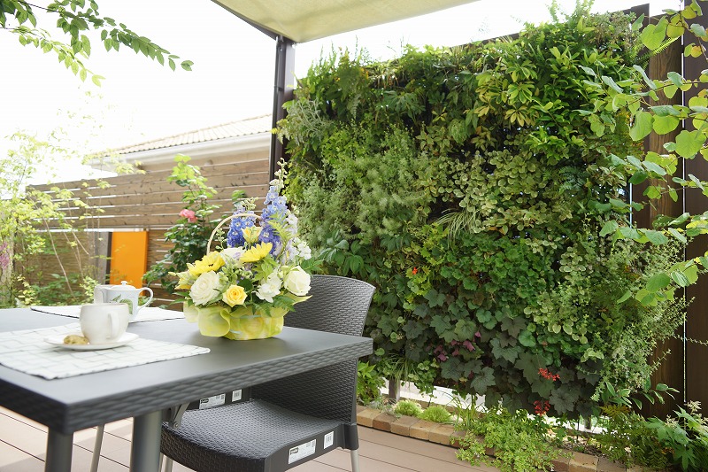 緑に囲まれたテラス席で談笑する家族の様子。