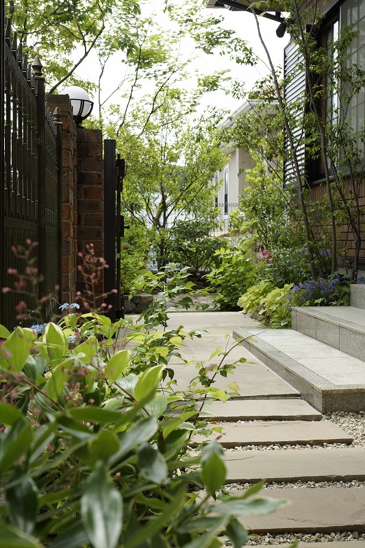 ウッドデッキと植栽が調和した落ち着いた庭の一角。