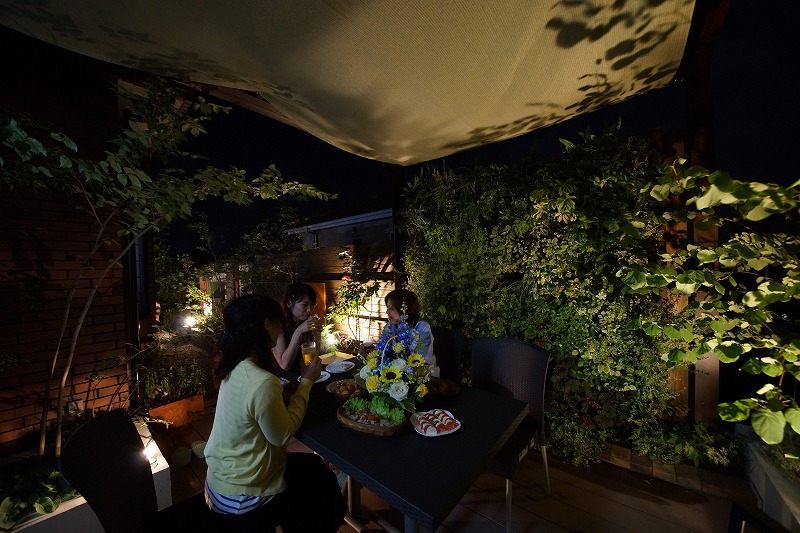 夜のテラスで家族が食事を楽しむ暖かい光のシーン。