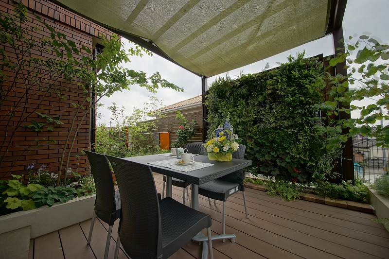 パーゴラとテーブルセットが設置され緑が広がるテラス空間に変わった庭。