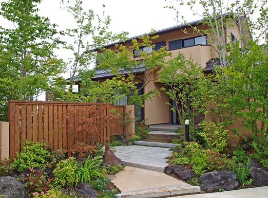 雑木と草花に包まれたアプローチと門周りの施工後外観。