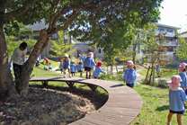 園庭の斜面で腰かけてくつろぐ子どもたち。