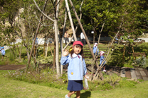 小さな丘の上に集まり、笑顔で遊ぶ園児たち。