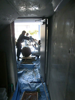 資材搬入に使われた間口60cmのくぐり扉とその先に見える庭づくりの様子。