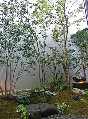 苔山と石のオブジェが配された庭の一角。