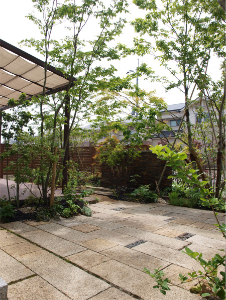 雑木に包まれたウッドデッキと植栽が広がる、完成後のデッキガーデン全景。