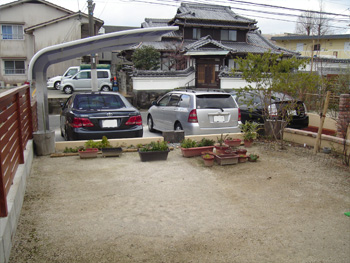 施工前の庭。土の地面が広がり、駐車スペースとして使われている様子。