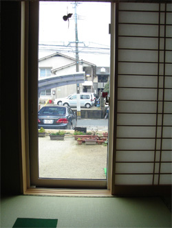 施工前の和室からの眺め。土の庭と駐車スペースが見える。