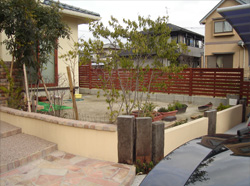 施工前のアプローチ。コンクリートと土の地面が目立つ玄関前の様子。