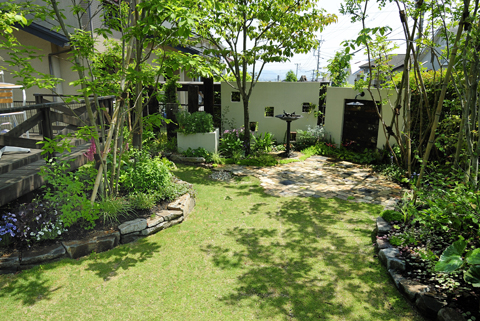 レンガと芝生、雑木が調和した、ナチュラルガーデンへと生まれ変わった庭。