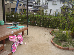 施工前のリビングからの眺め。砂地の庭とフェンスが見える。