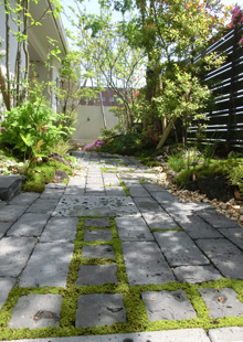 レンガ敷きの小径と、目地に入った苔が柔らかな表情をつくる足元。